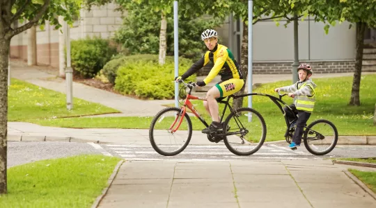 Man riding a bike with a child.