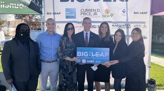 Multiple people holding the Big Leap sign