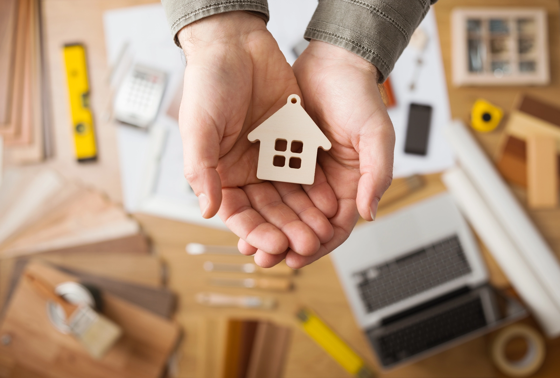 Two hands holding a house-shaped trinket