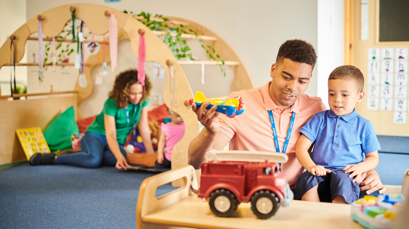 An male educator engages a young child in a TK classroom setting in Los Angeles, illustrating the nurturing, play-based environment of Transitional Kindergarten offered through LAUSD and local charter schools.